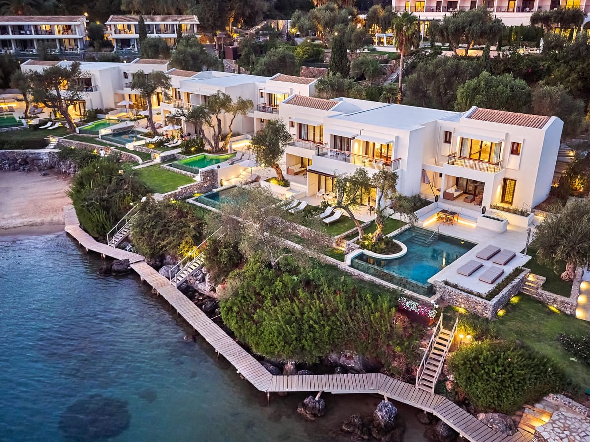 Waterfront villas with private pools at dusk, Grecotel Corfu Imperial